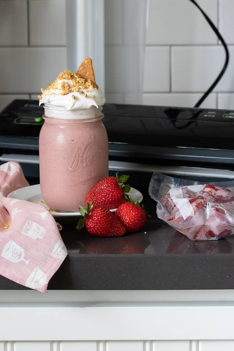Strawberry smoothie on a kitchen counter in front of a Foodsaver machine