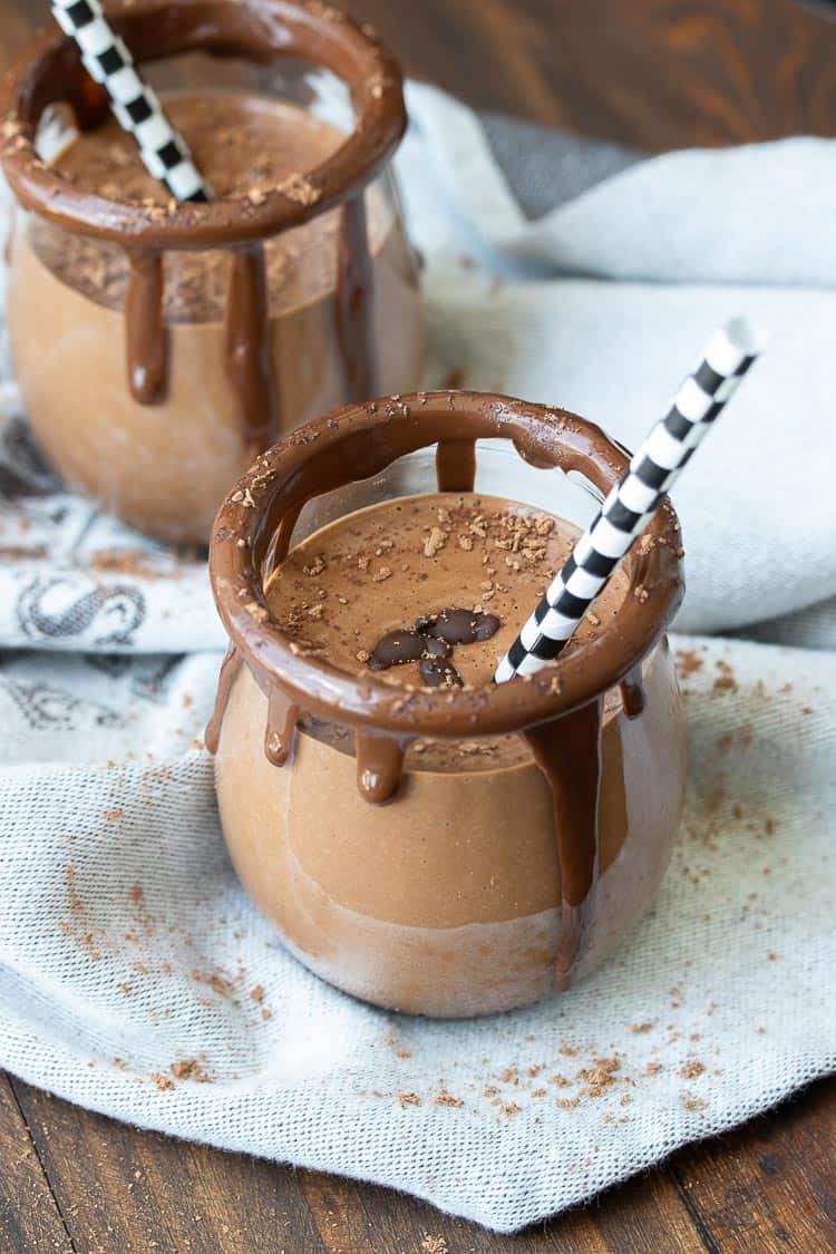 Top side view of a chocolate smoothie in a glass jar rimmed with chocolate