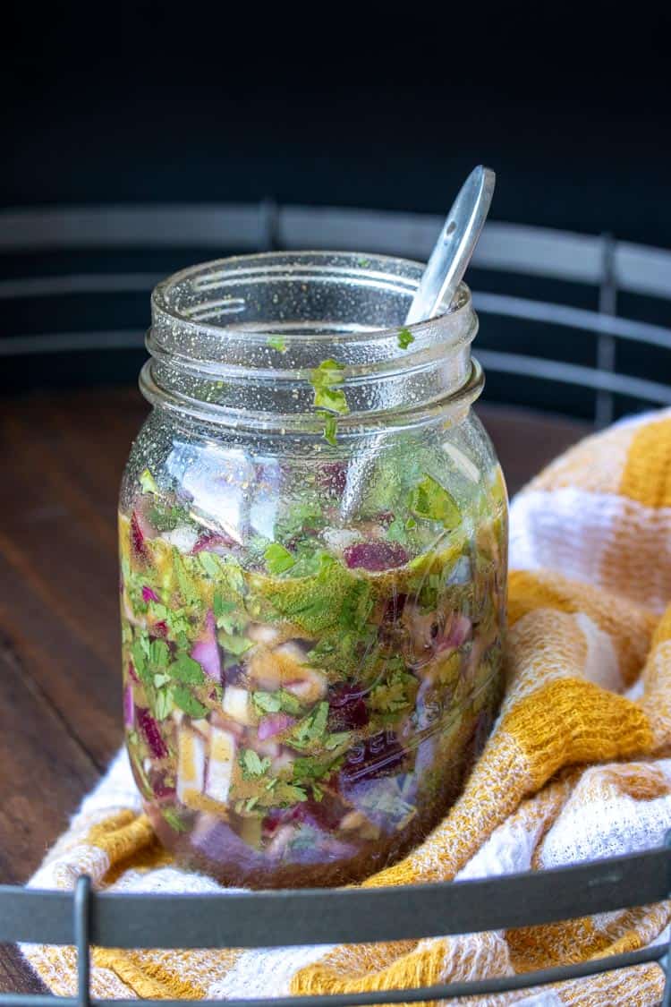 Glass jar with onions, cilantro, vinegar and oil in it