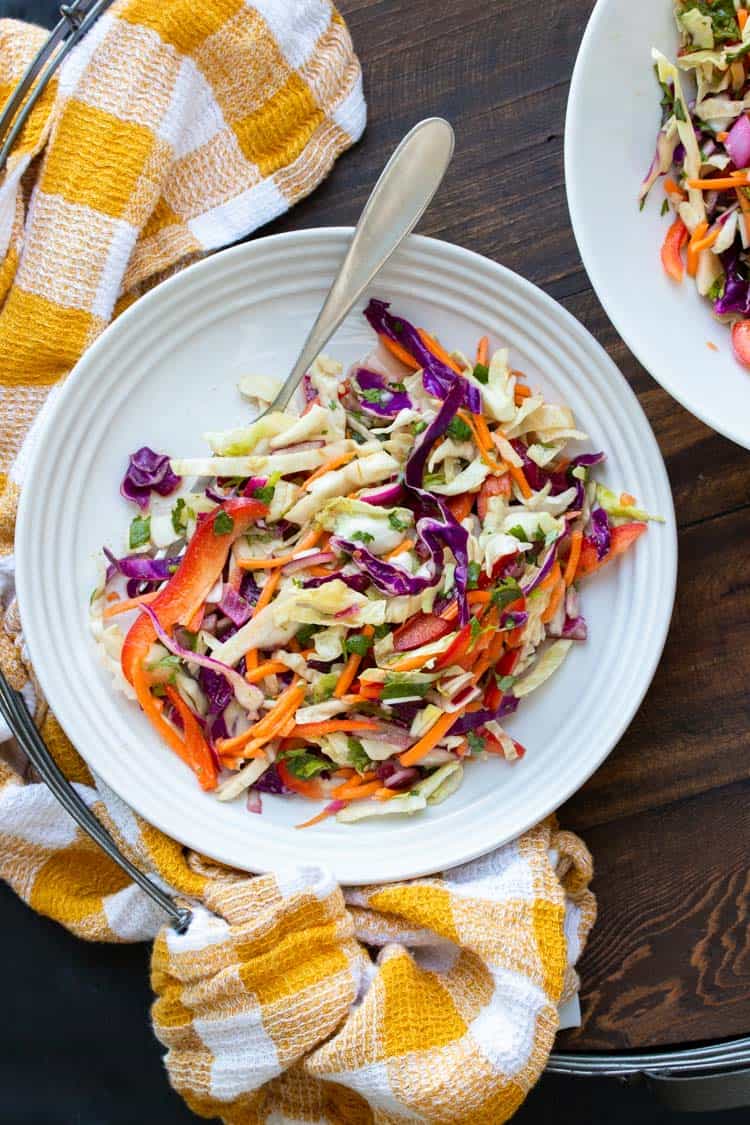 Fork on a white plate with veggie coleslaw on it