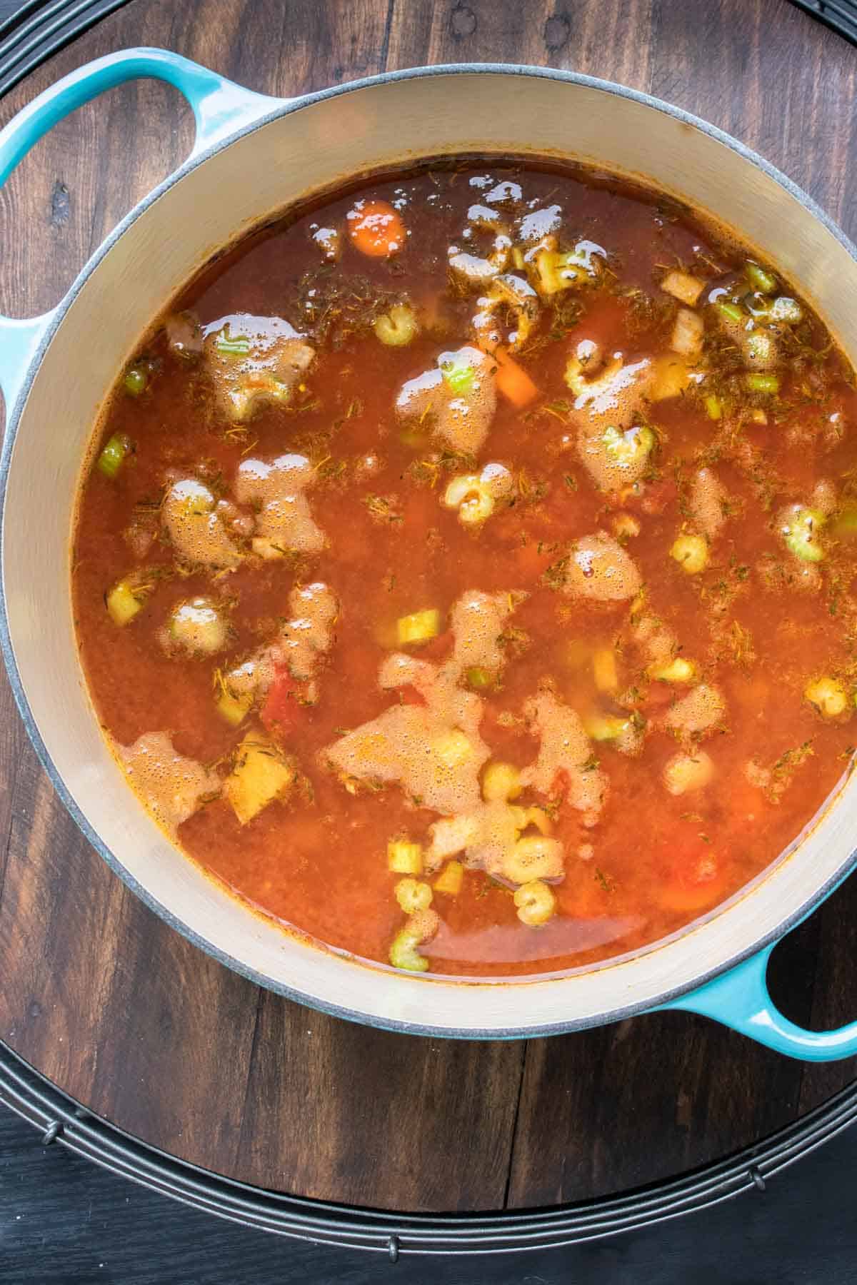 Top view of dutch oven with a red veggie lentil soup inside