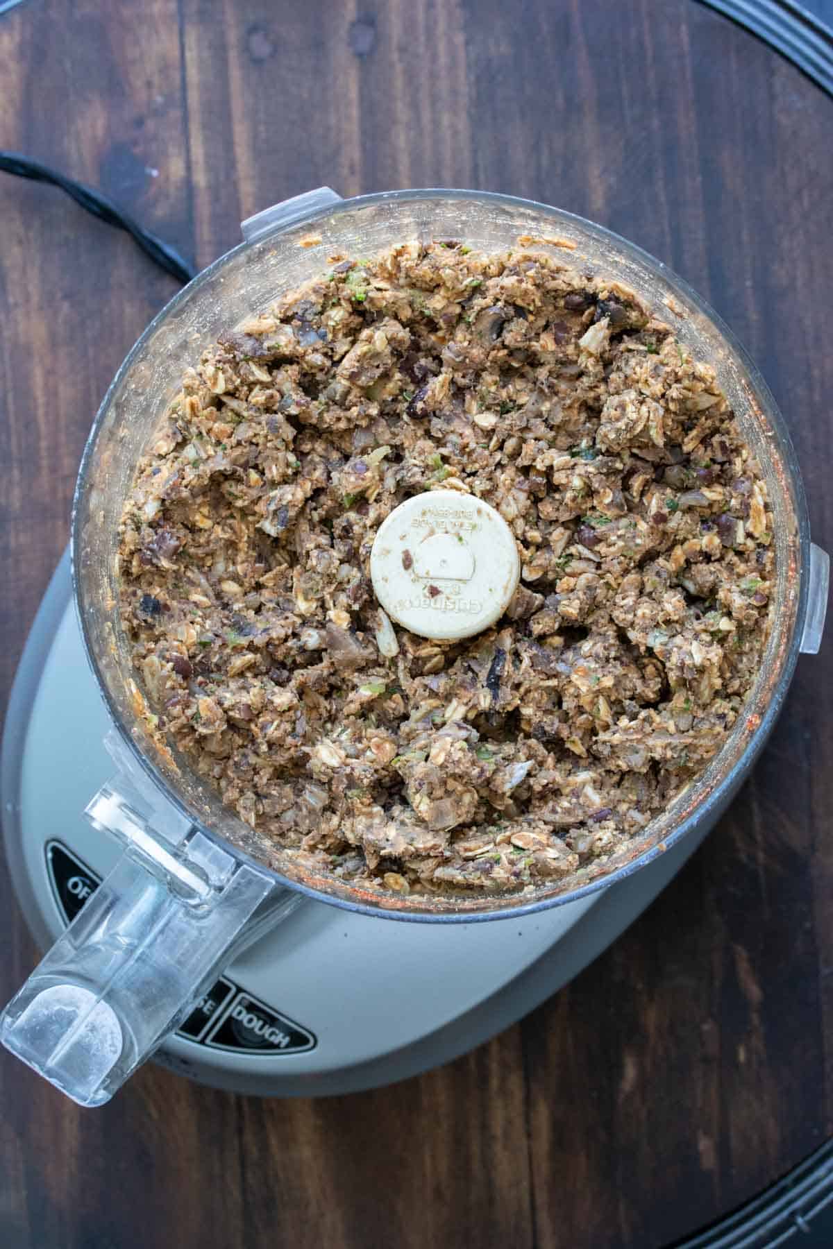 Top view of food processor with veggie burger mixture in it.