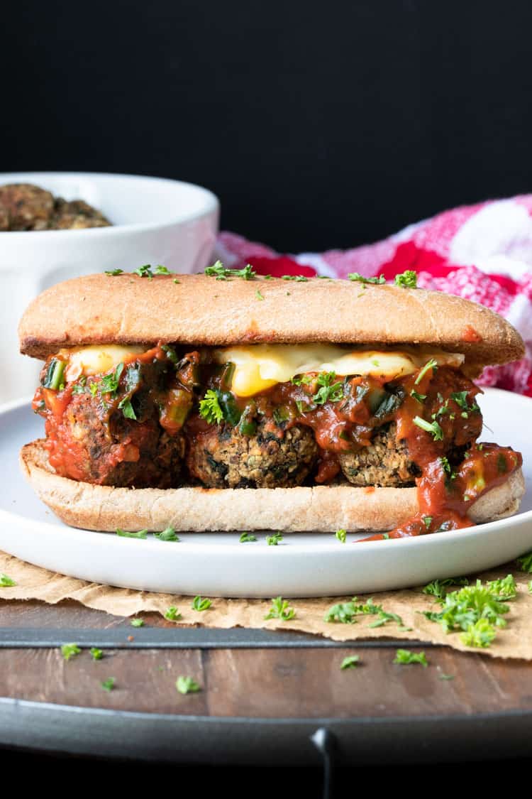 Cheese and marinara over vegan meatballs in a sub sandwich