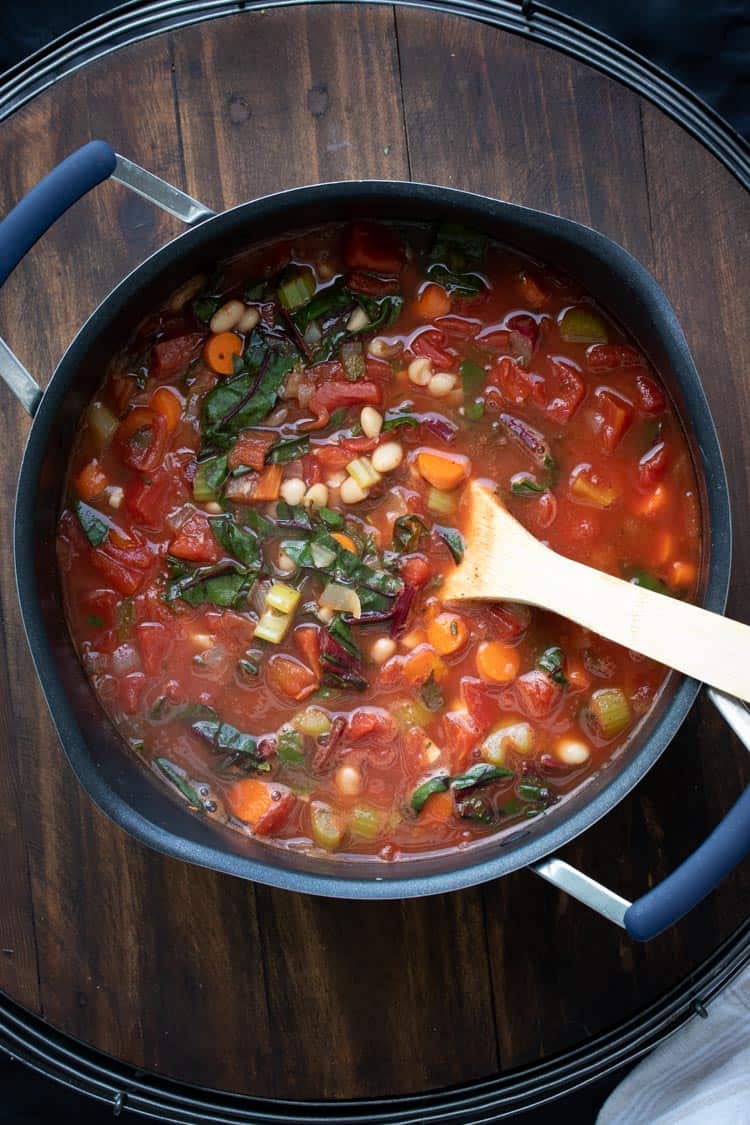 Tomato based vegetable soup with beans and chard in a pot