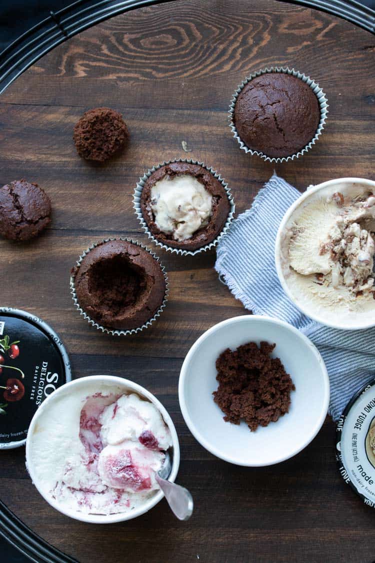 Cupcakes with holes in the center being stuffed with ice cream