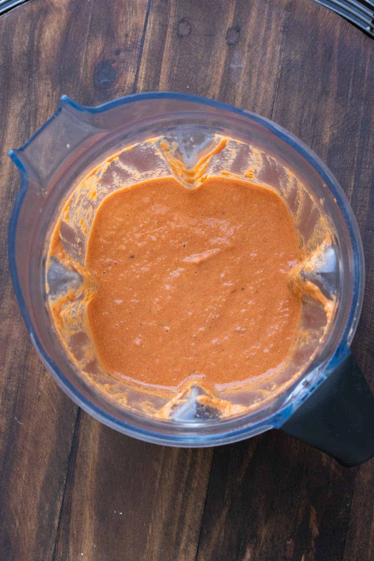 Top view of a blender with creamy tomato soup inside.