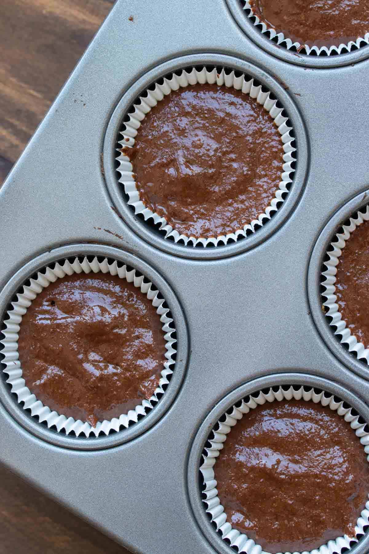 Cupcake batter in cupcake liners in a muffin tin