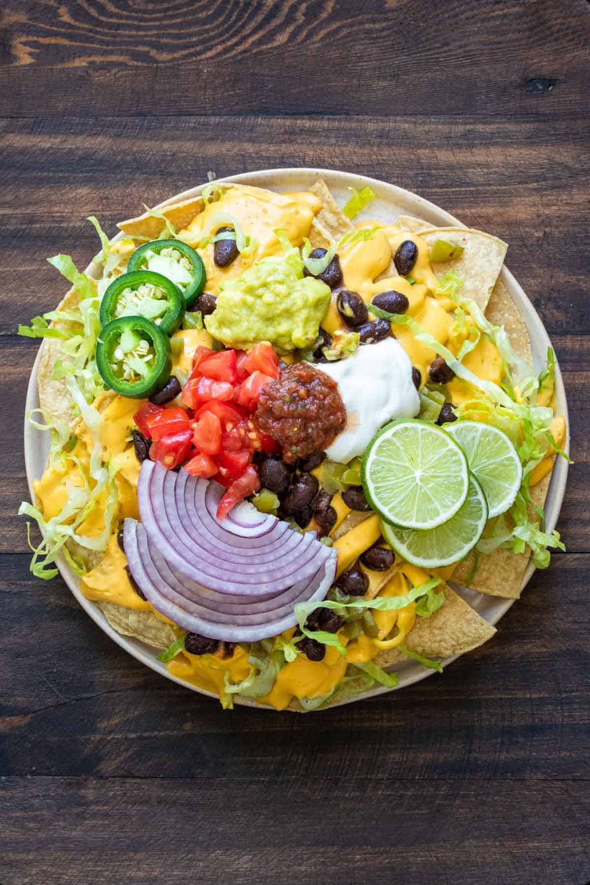 Plate of nachos piled high with ingredients