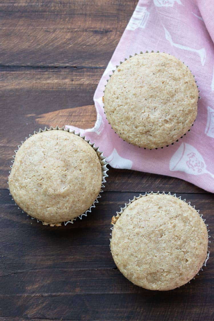 Top view of baked vanilla cupcakes on a wooden table