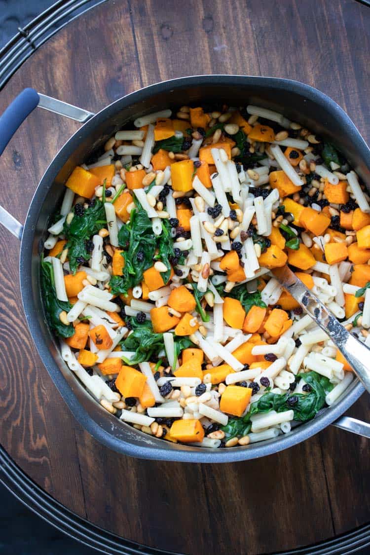 Pot filled with penne pasta, butternut squash and spinach