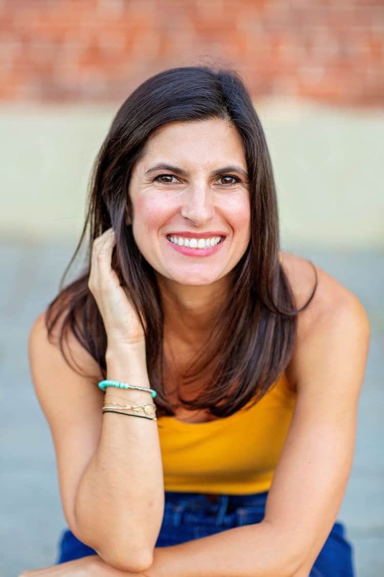 Woman leaning on knees wearing a yellow tank top