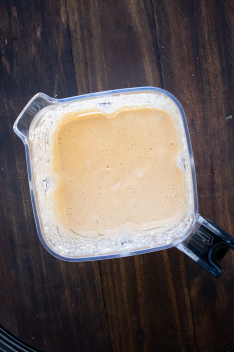 Top view of blender with peach looking creamy sauce