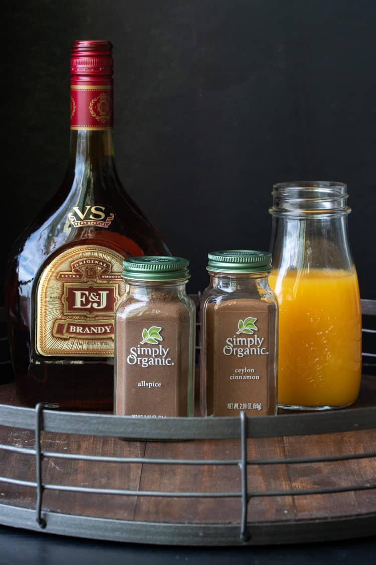 Brandy, orange juice and spices on a wooden tray