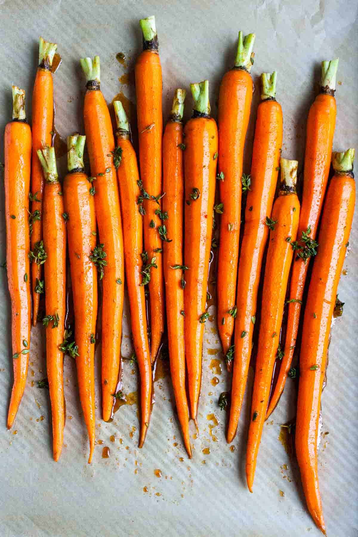 Carrots being roasted on a baking sheet