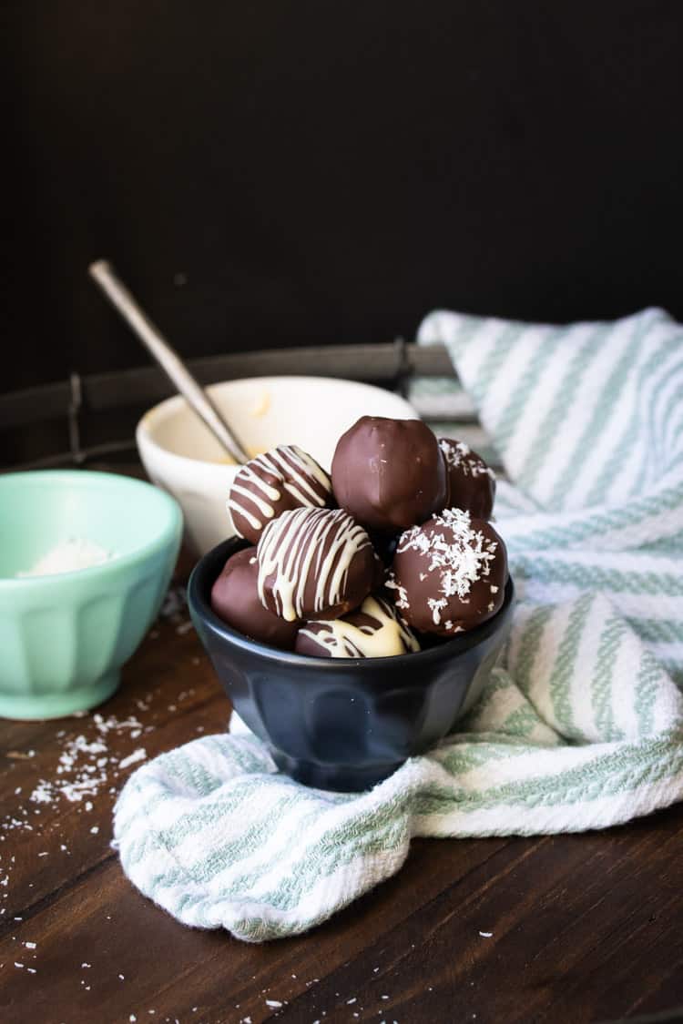 Black bowl filled with decorated chocolate covered peanut butter balls