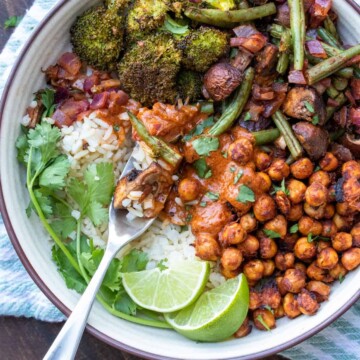 Fork getting a bite of rice with tikka masala sauce and roasted veggies and chickpeas