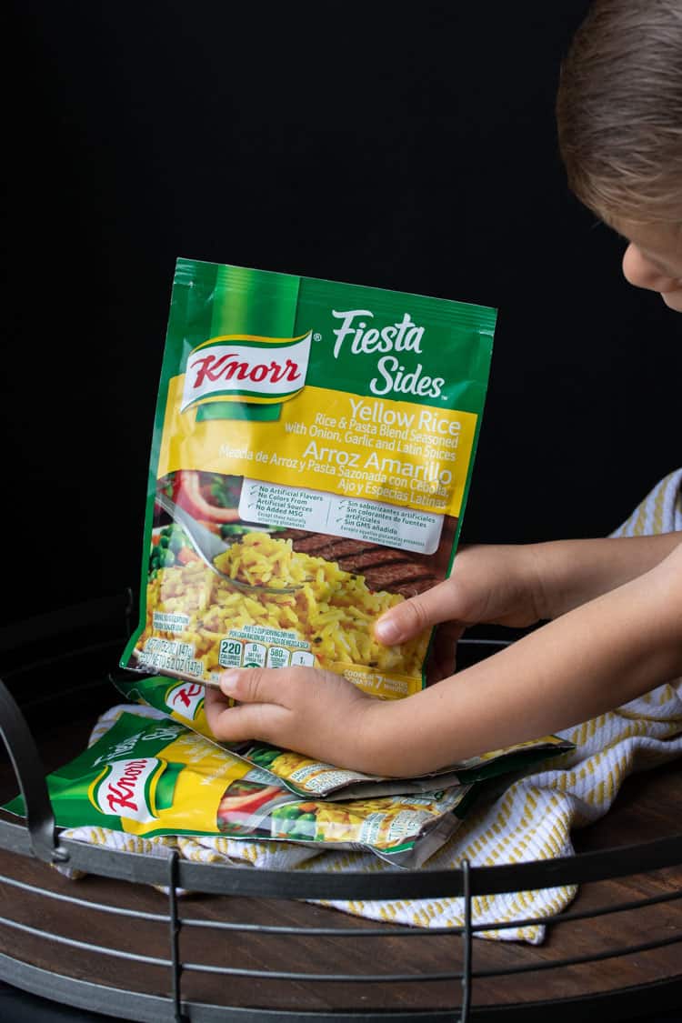 Child holding a package of Knorr brand rice mix