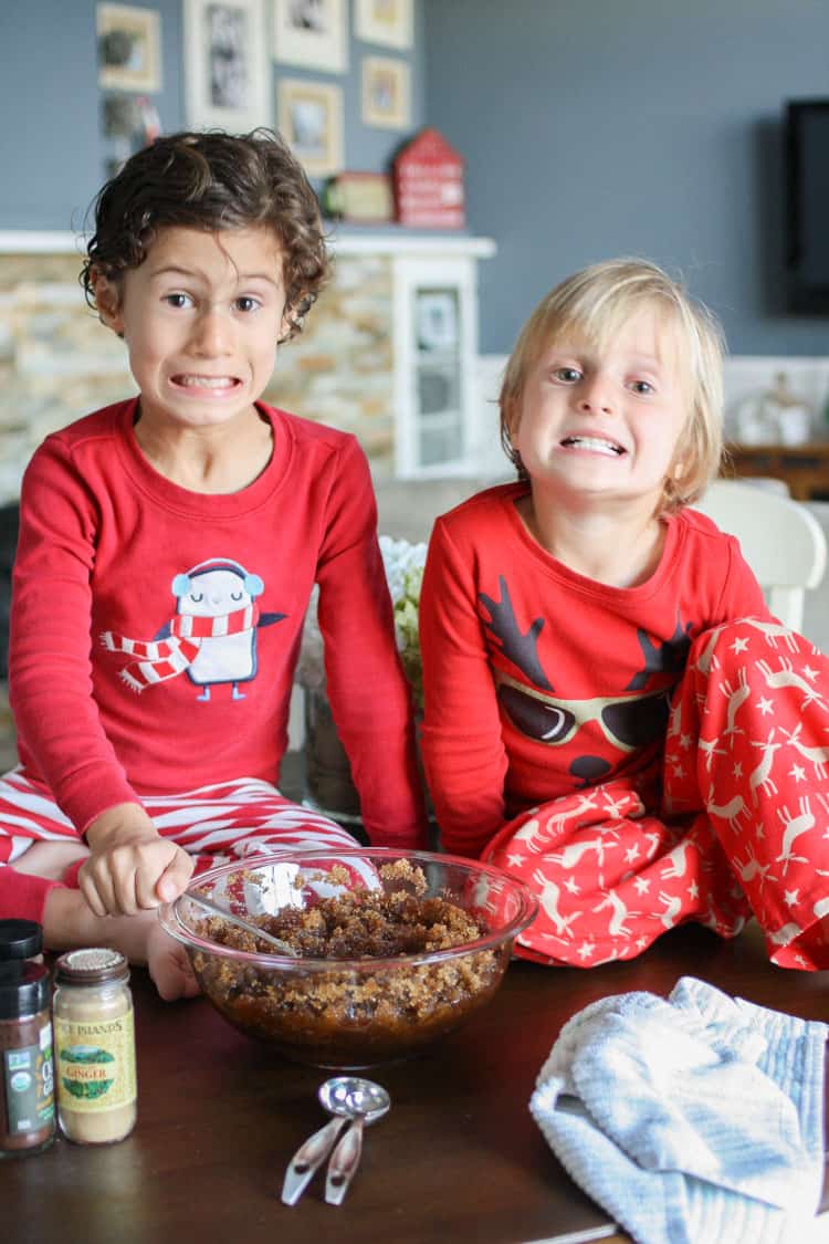 Two boys sitting on a table making homemade sugar scrub in a bowl