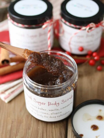 A knife getting out a scoop of homemade sugar scrub from a jar