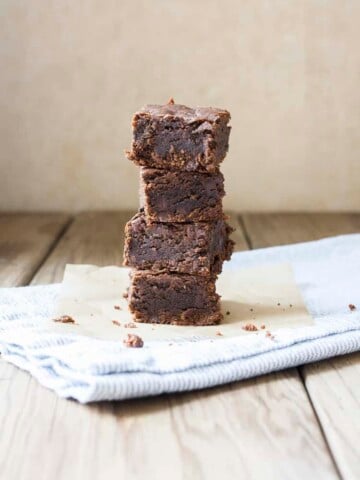 Pile of four brownies on a grey towel