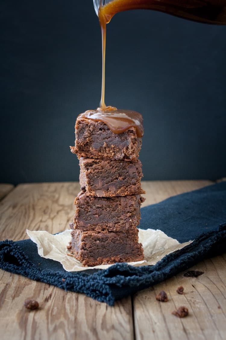 Caramel sauce pouring on a tower of brownies