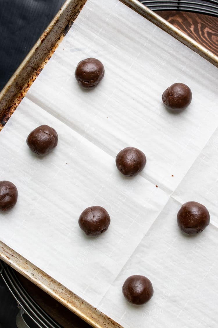 Brownie dough balls on a piece of parchment paper