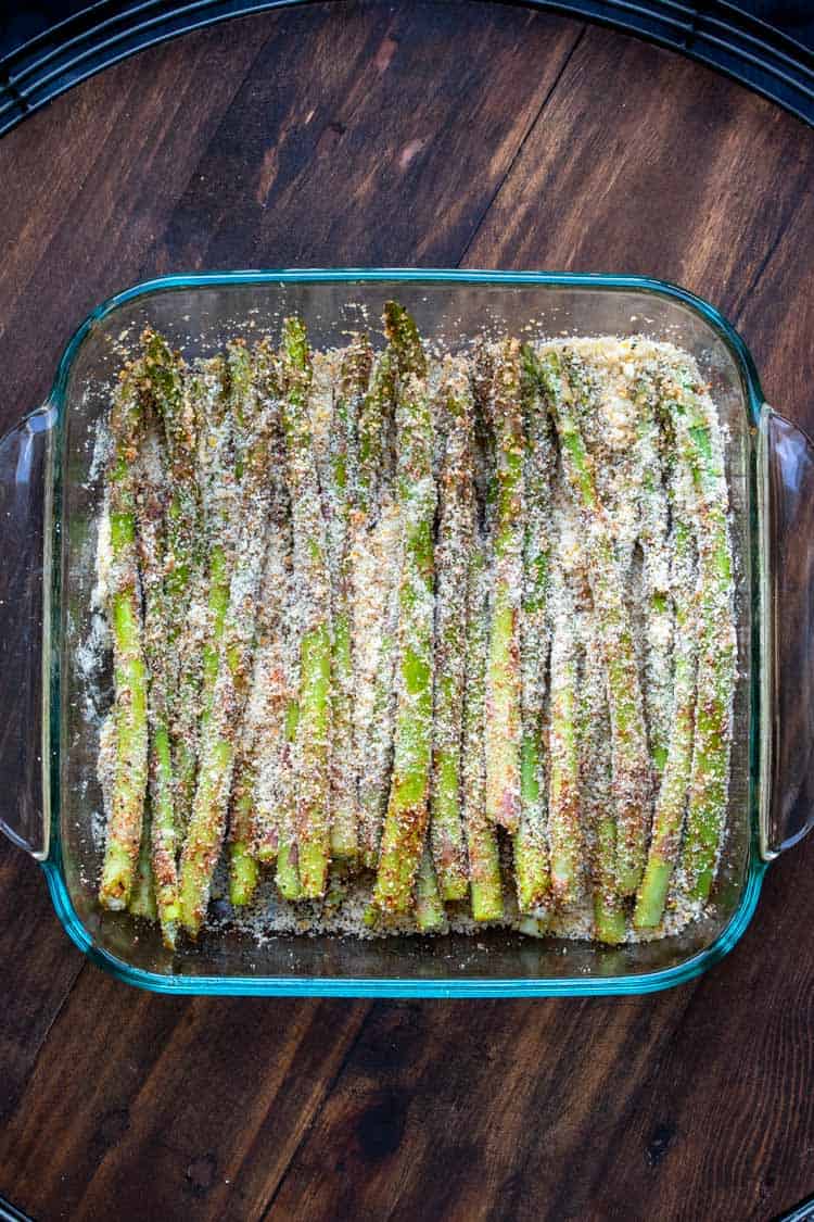 Breaded asparagus spears in a glass baking dish