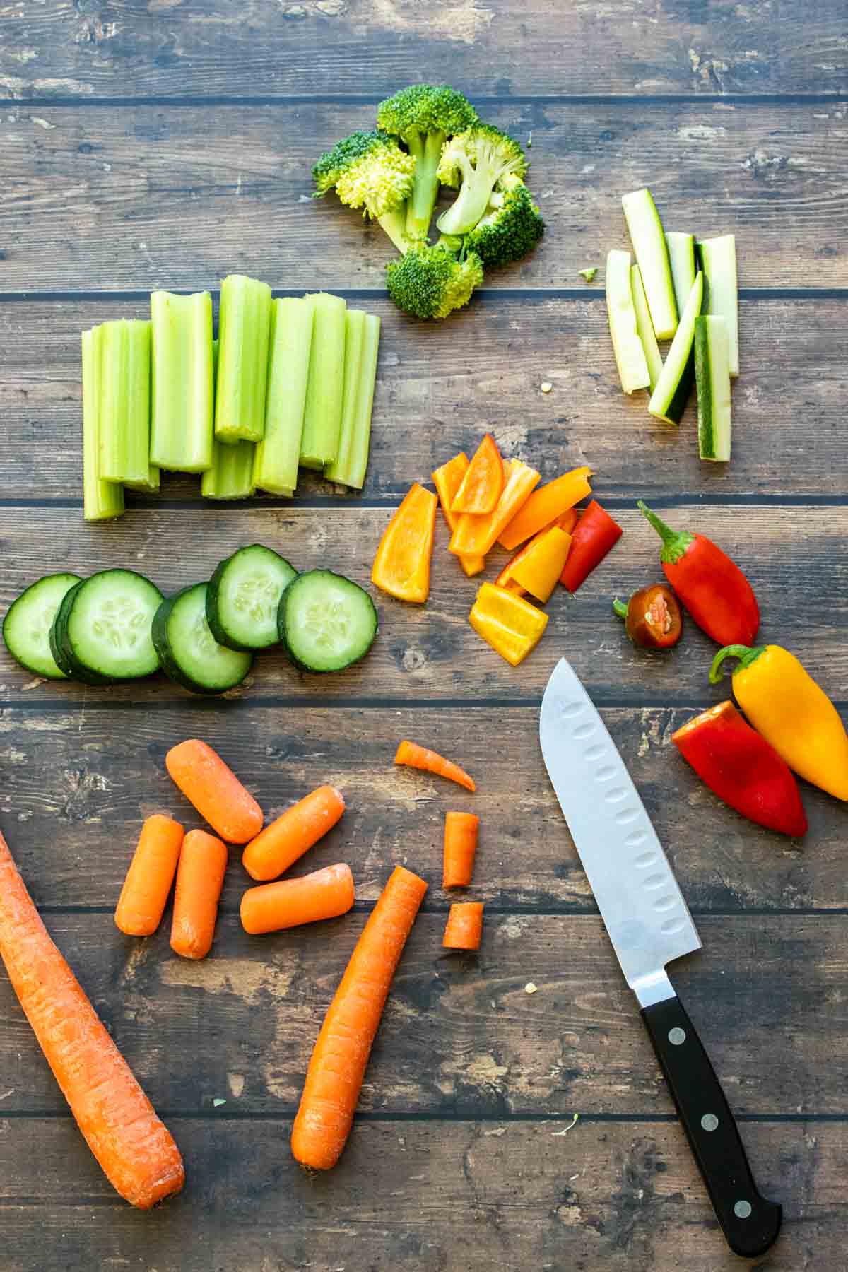 Veggies that have been chopped and sliced on a wooden surface.