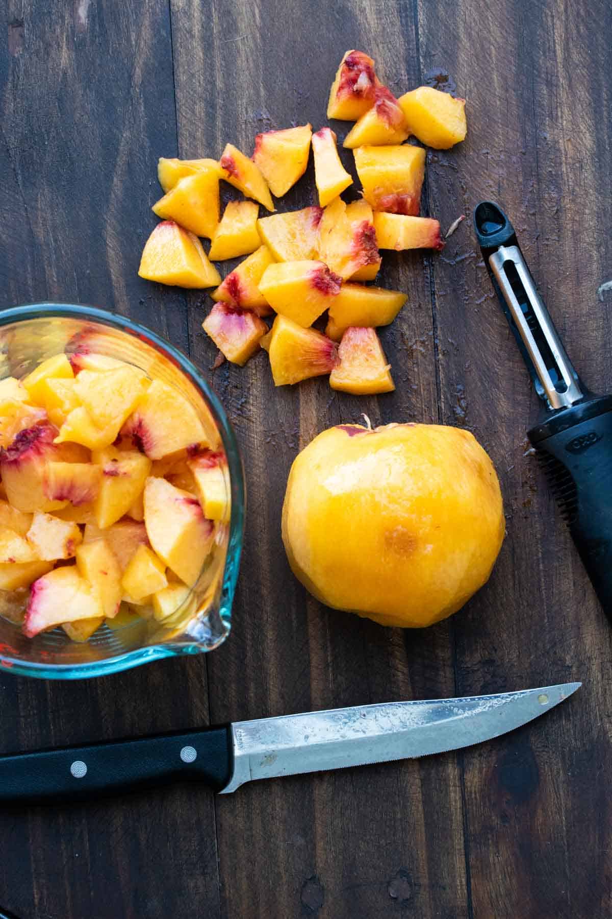 Peach being peeled and chopped into pieces.