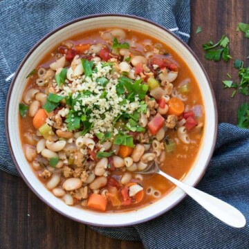 White bowl with pasta and vegetable bean soup inside