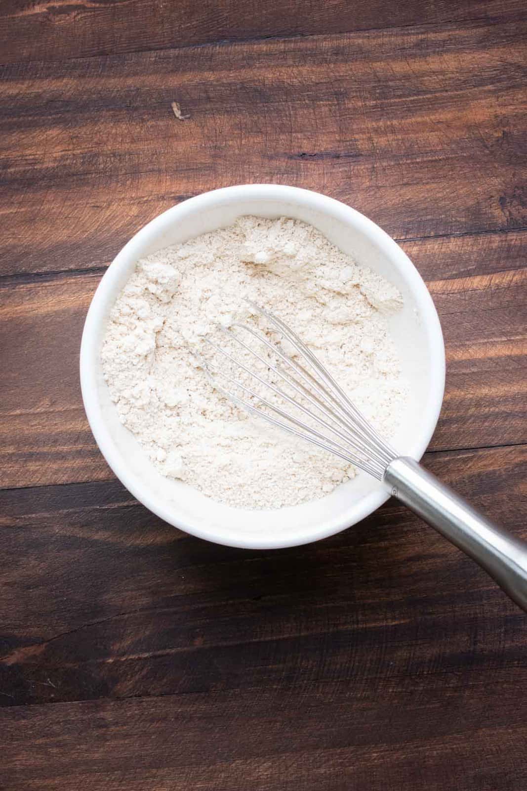 Whisk mixing flours in a white bowl