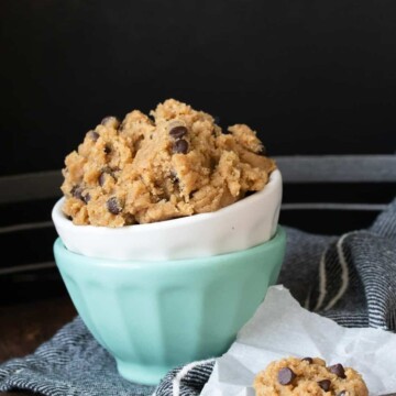 White bowl with raw cookie dough inside a turquoise bowl