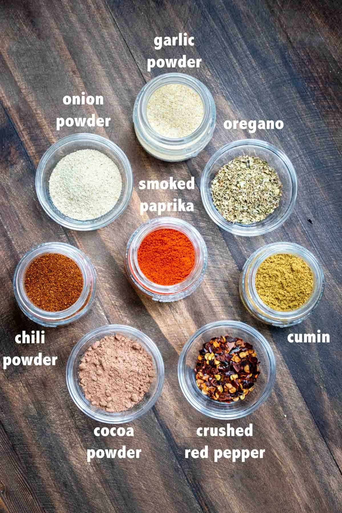 Top view of jars filled with spices to make taco seasoning and overly text of their names