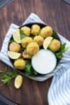 Black bowl filled with baked falafel and tahini dip