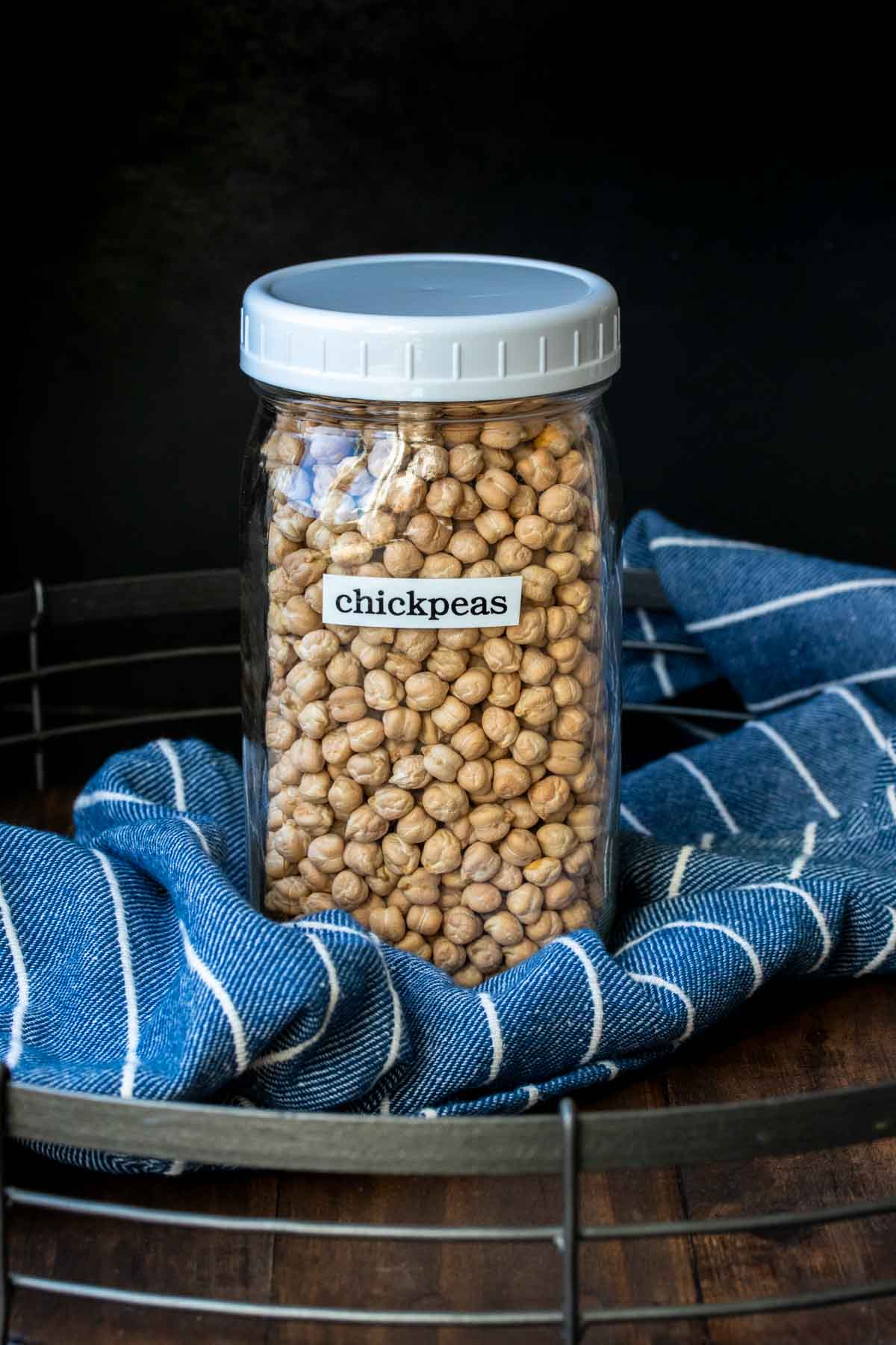Glass jar with white plastic lid filled with dried chickpeas