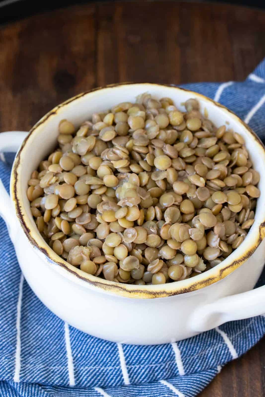 White soup bowl filled with cooked brown lentils