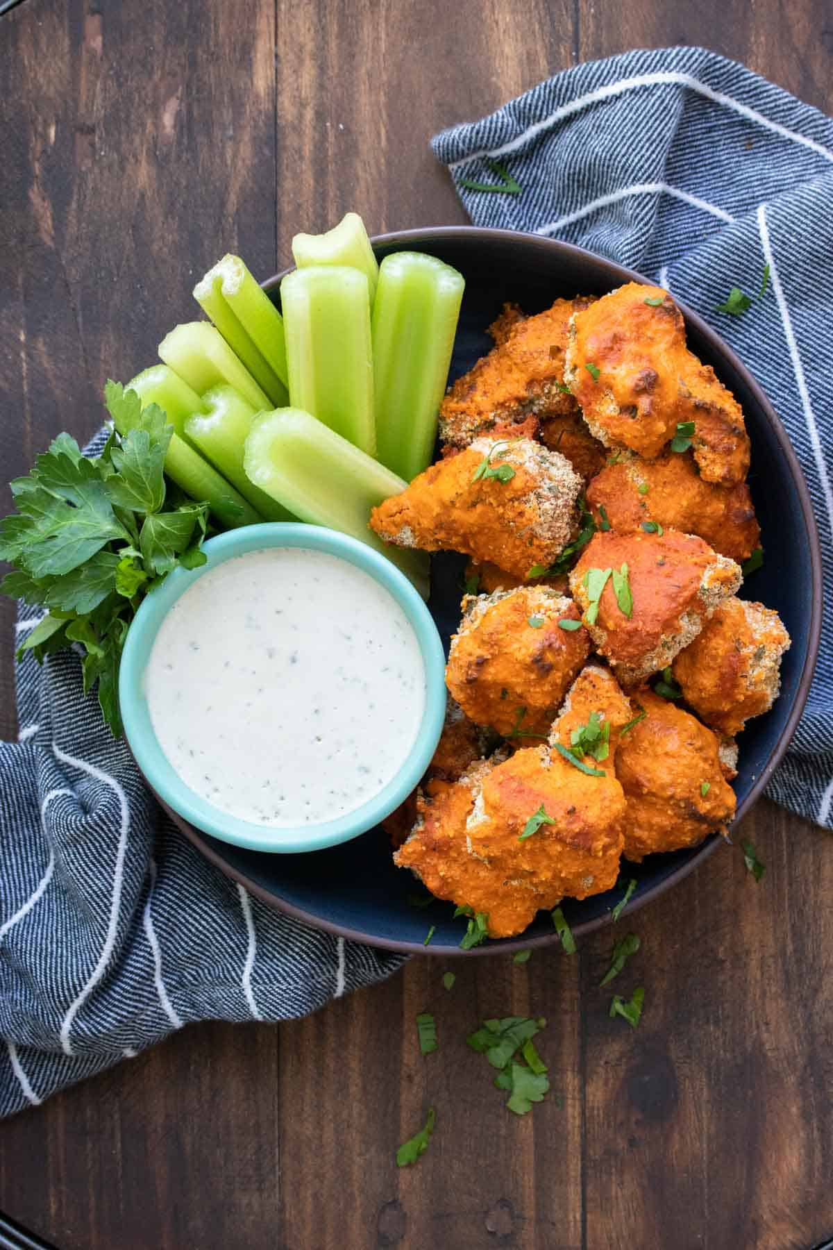 Black bowl filled with crispy cauliflower covered in buffalo sauce
