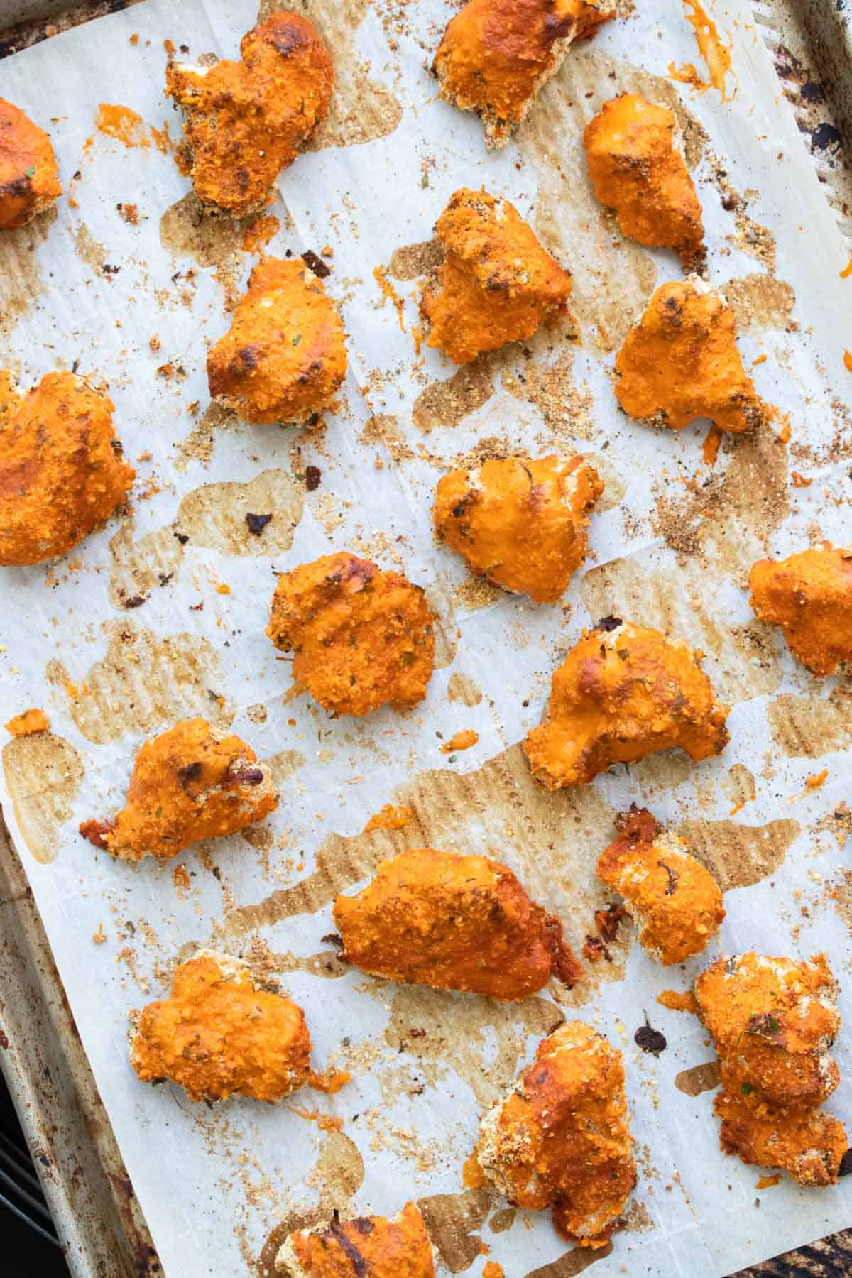Crispy baked cauliflower wings on a parchment lined baking sheet.