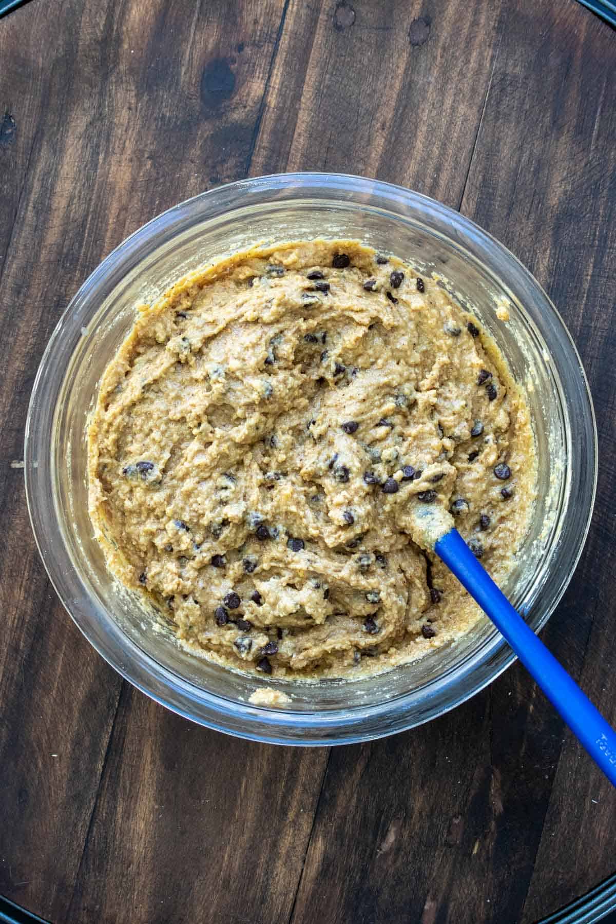 Chocolate chip blondie batter being mixed in a glass bowl