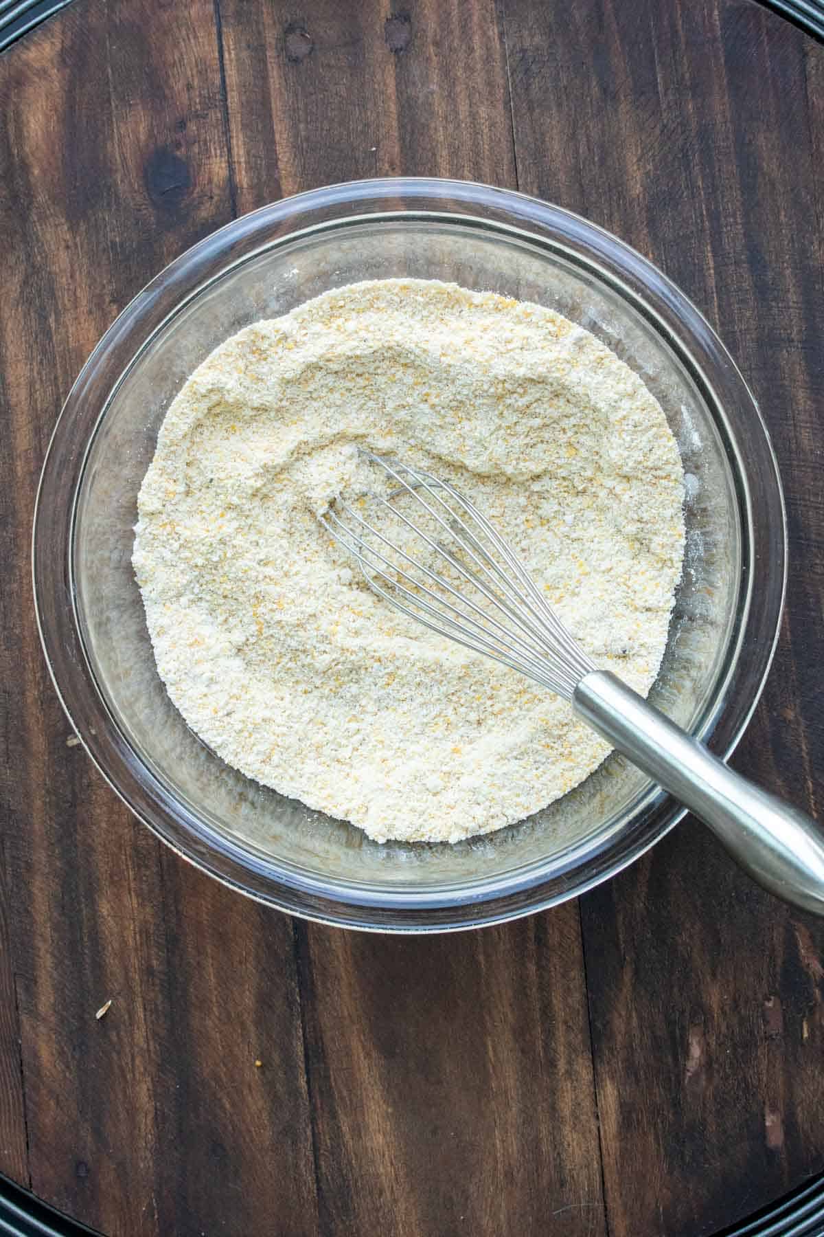 Whisk mixing flour and cornmeal in a glass bowl