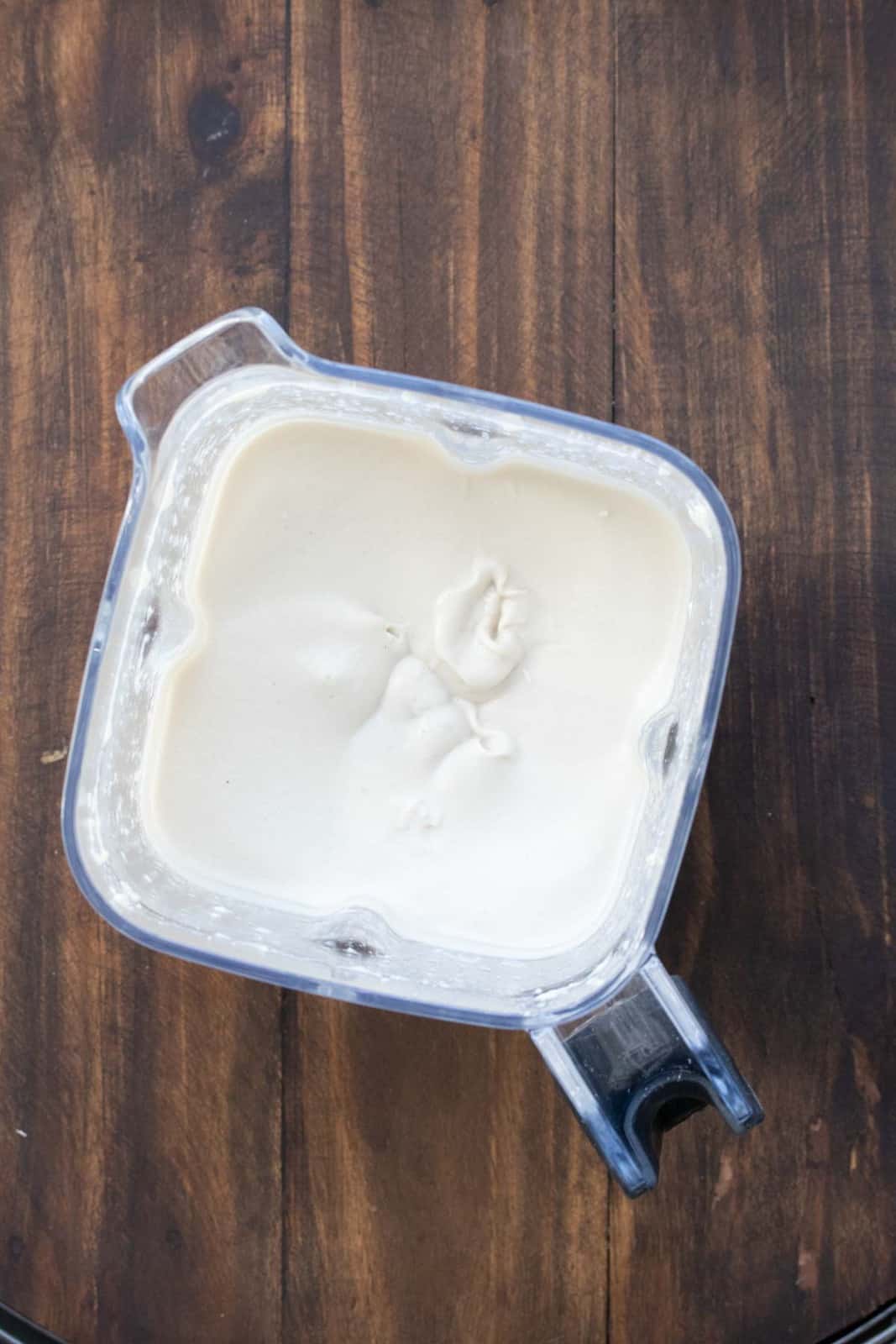 Top view of a blender with tahini sauce in it