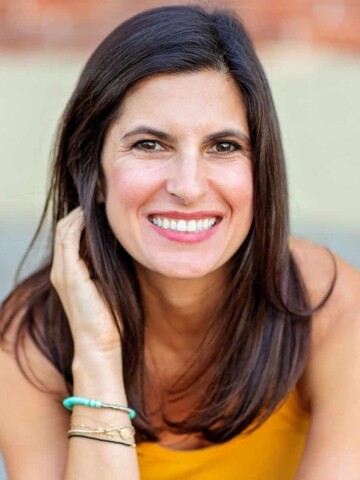 Photo of a woman in a yellow shirt smiling at the camera