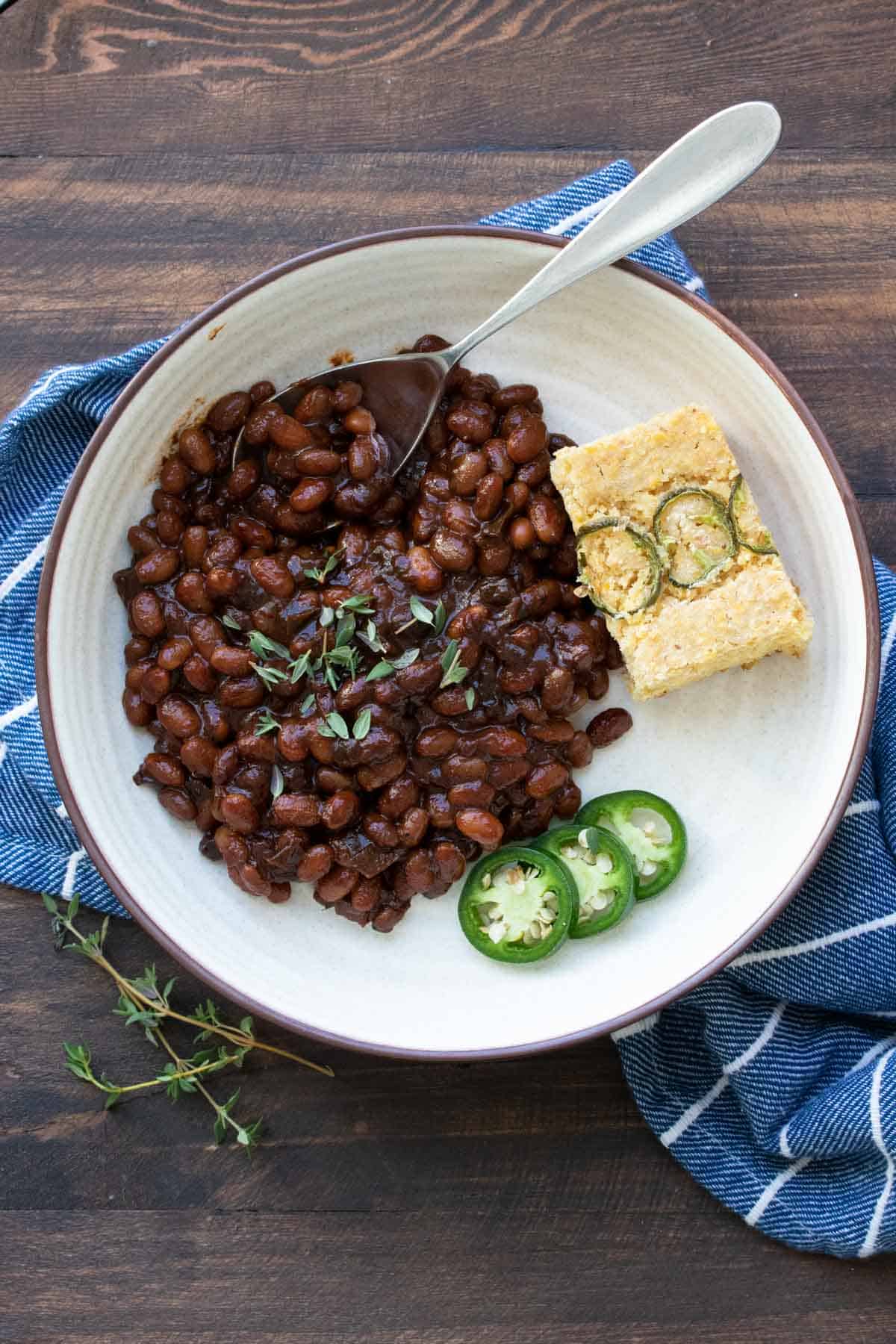 Cream plate with baked beans, jalapeno slices and cornbread