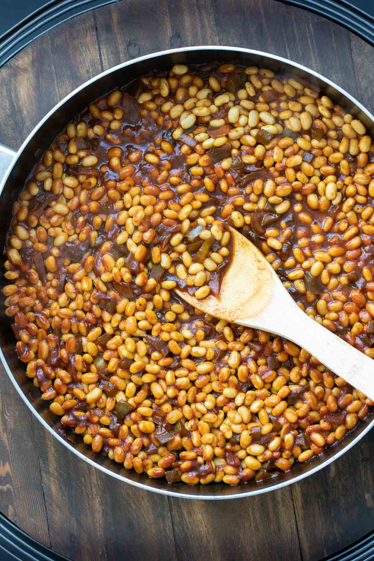 Beans in a pan with ingredients for a baked bean sauce