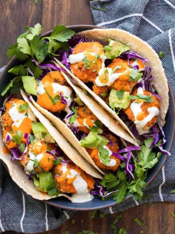 Craving comfort food? These buffalo cauliflower tacos are the perfect solution for a crispy baked, veggie filled, wrapped in a tortilla kind of meal! #vegantacos #healthycomfortfood