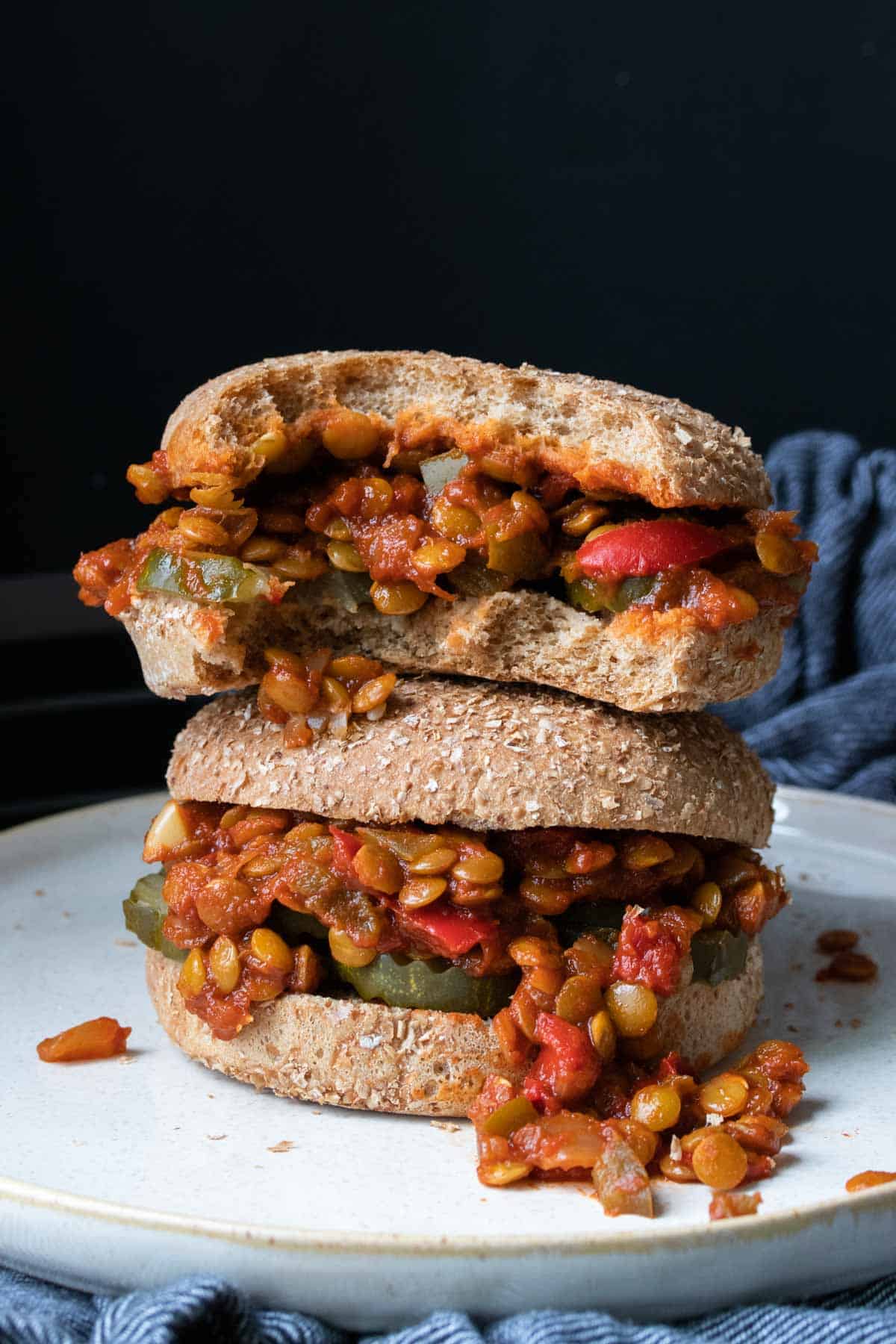 Pile of two lentil sloppy joes with a bite out of the top one.