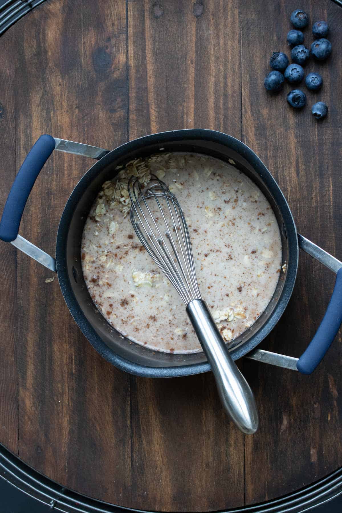 Whisk mixing milk and oats in a pot