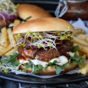 Portobello mushroom burger on a bun with lettuce, sprouts and sauce