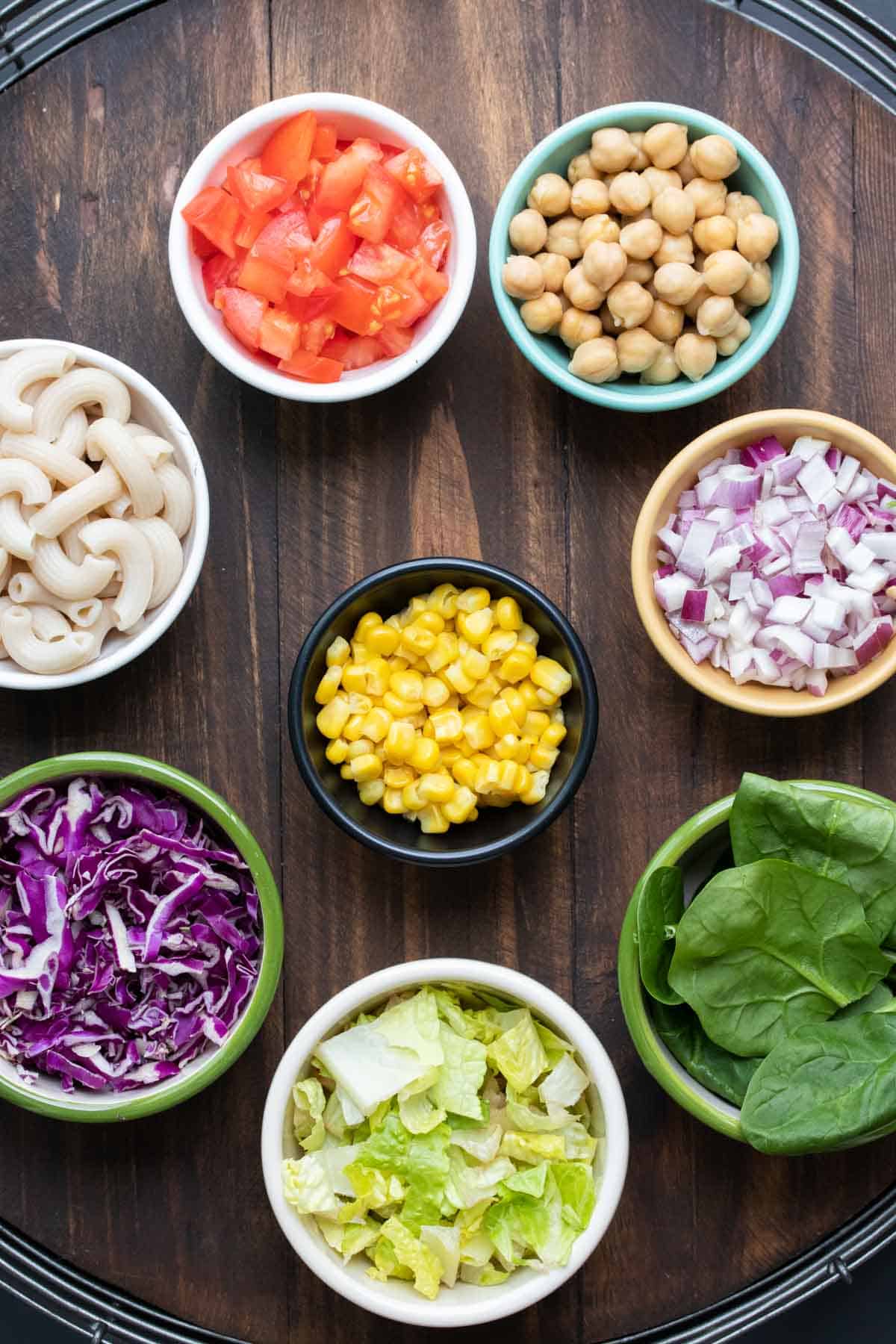 Colorful bowls with salad ingredients on a wooden surface