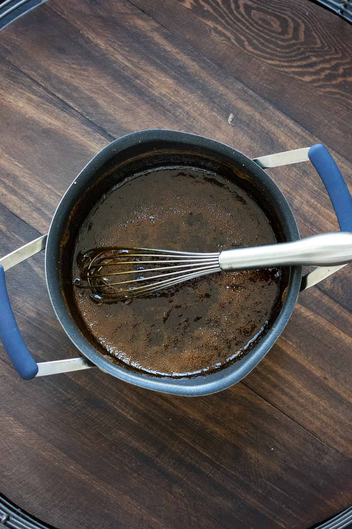 Whisk mixing up teriyaki ingredients in a pot